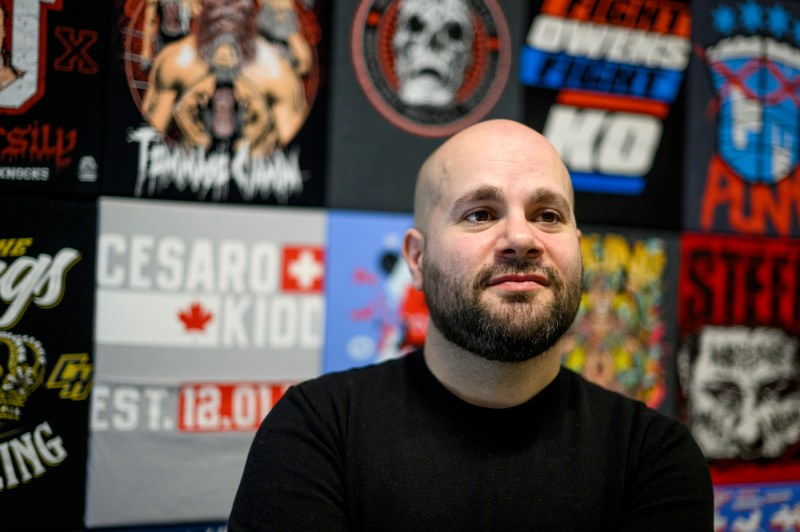 Portrait of Steve Granelli in front of a wall of graphic posters. 
