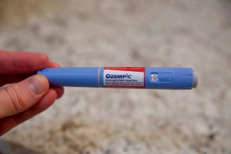 hand holding an Ozempic pen