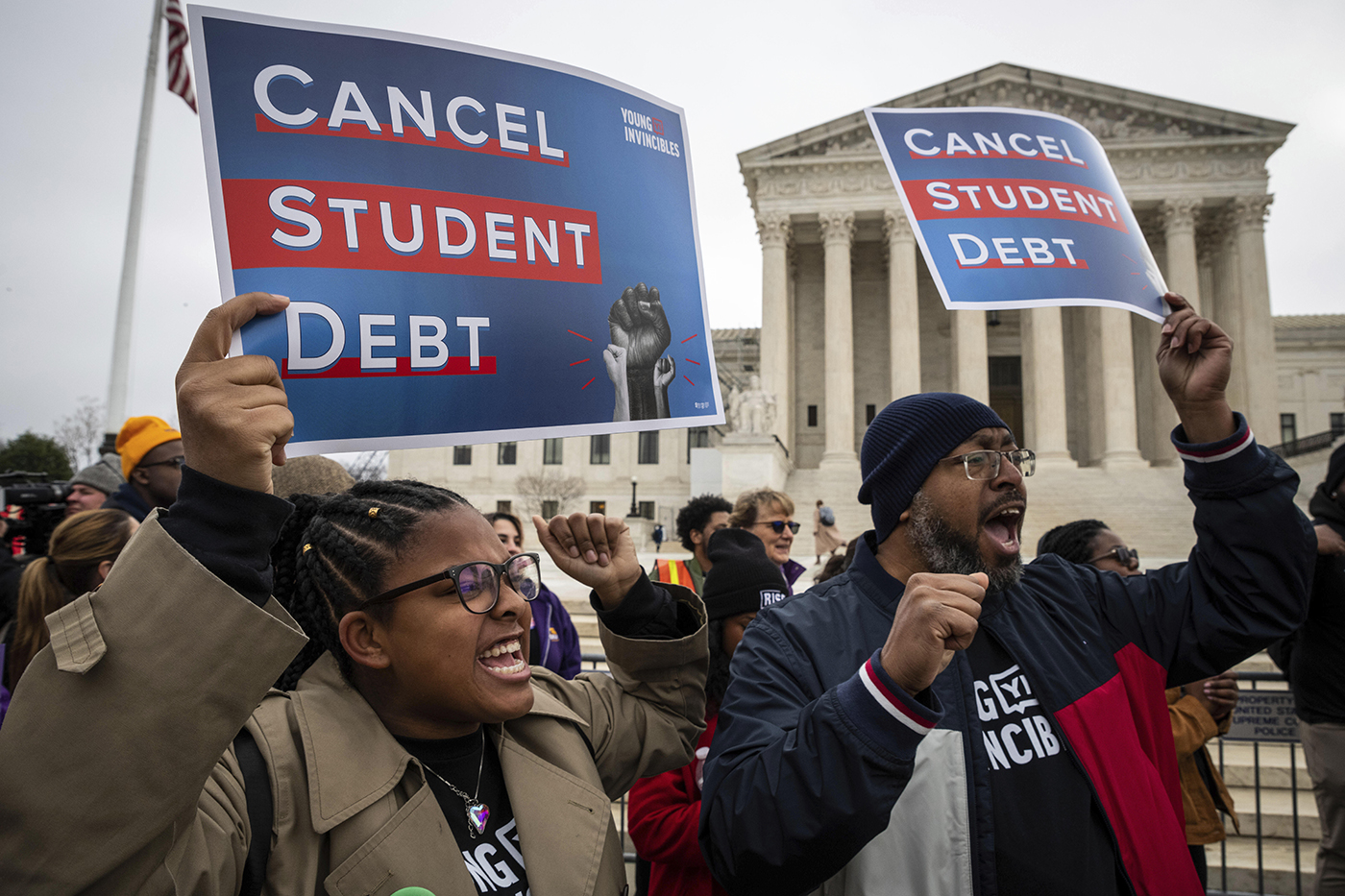 protestors holding 'cancel student debt' signs outside of the supreme court