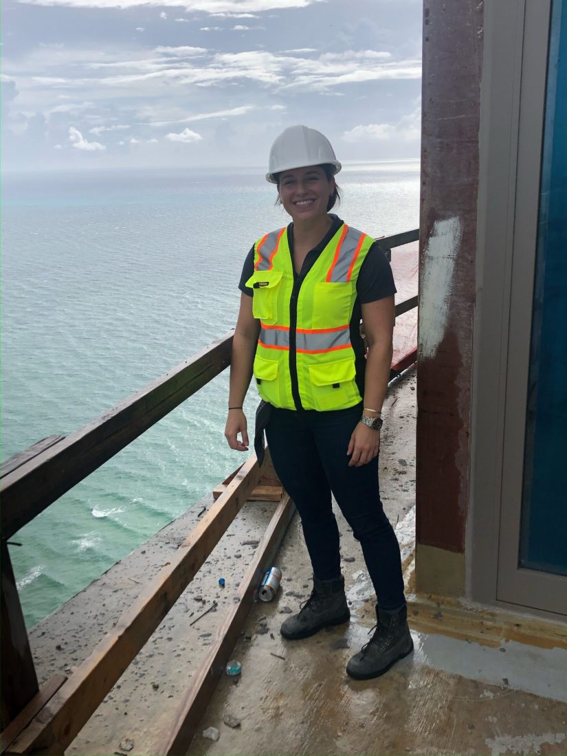 carrie caston in hard hat and high visibility vest standing in construction site overlooking ocean