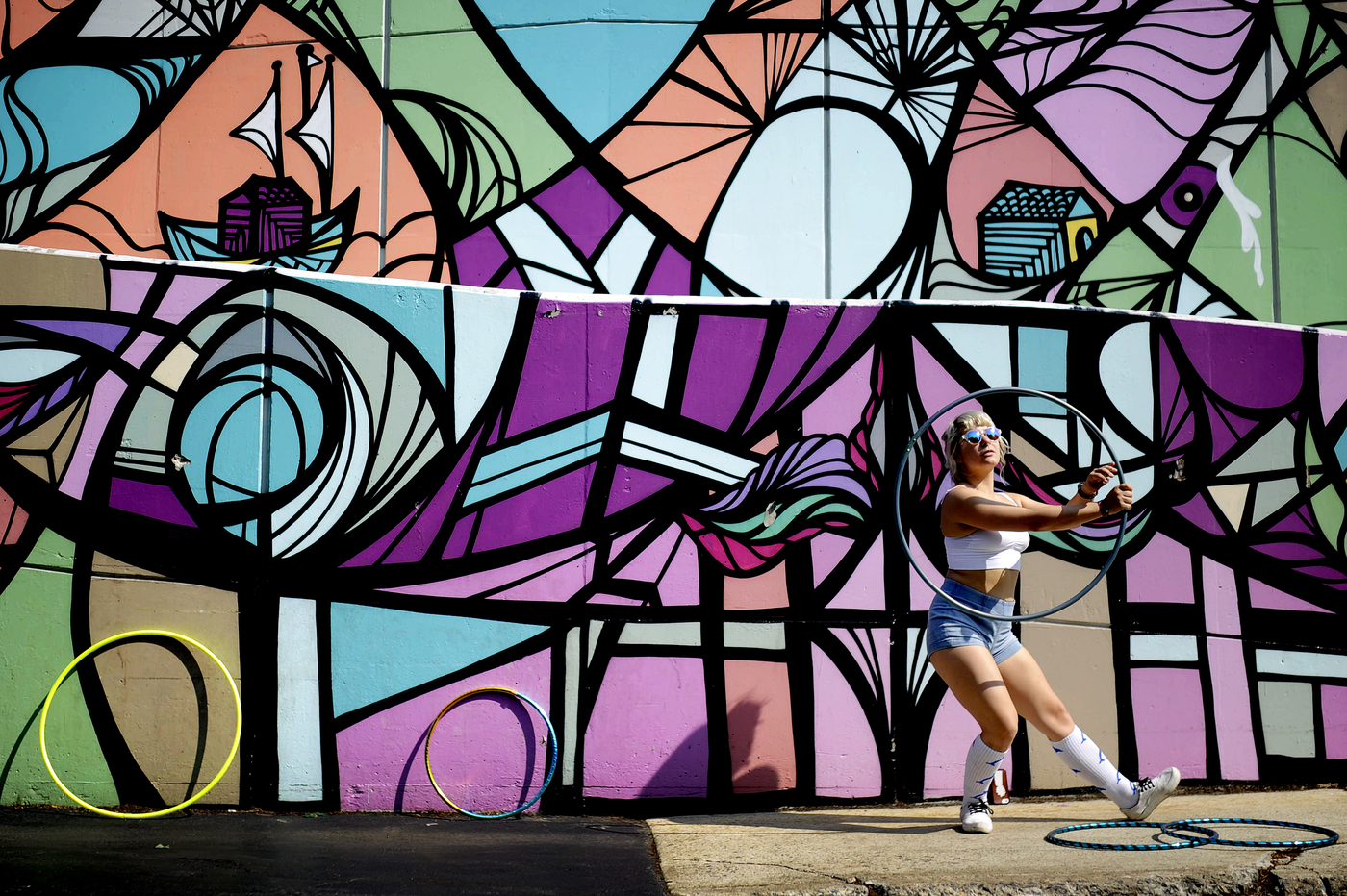 student dancing outside in front of art mural