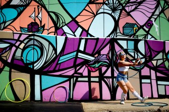 student dancing outside in front of art mural