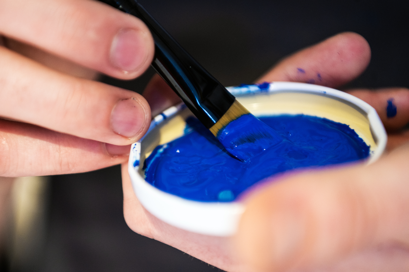blue paint in a jar lid