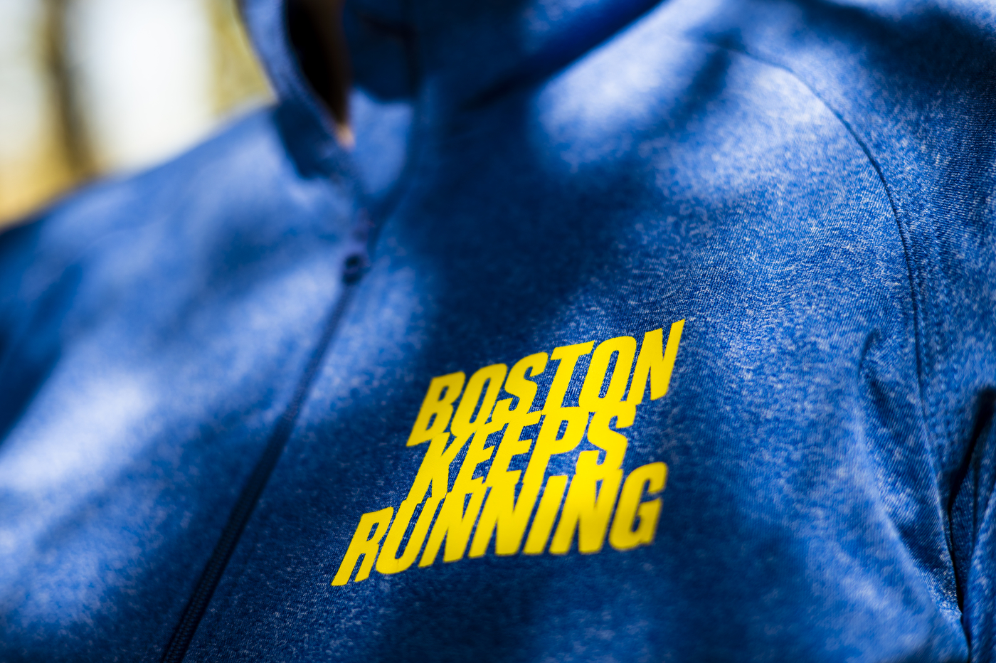 blue shirt with "Boston Keeps Running" yellow text on it