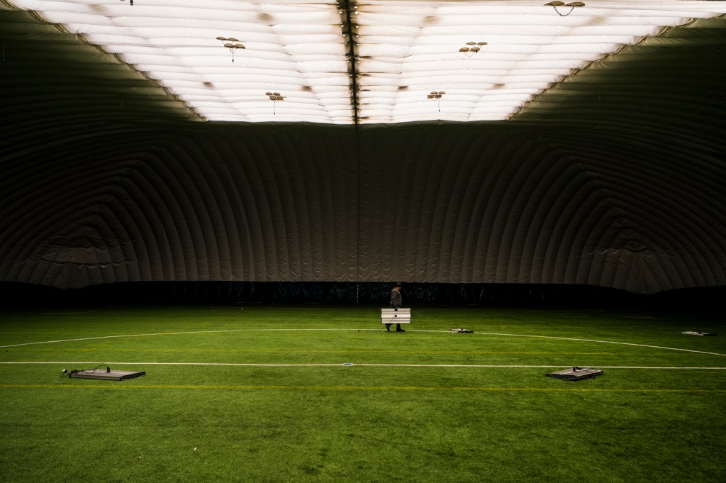 An Eamco company staff member carries a ceiling light inside of a dome.