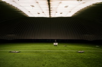 An Eamco company staff member carries a ceiling light inside of a dome.