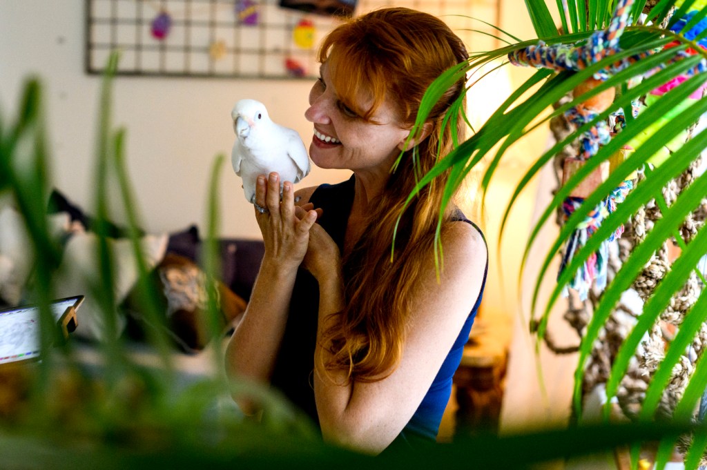 Jennifer Cunha holds a parrot.