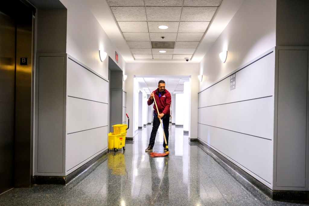 staff member of All Time Service cleaning a hallway