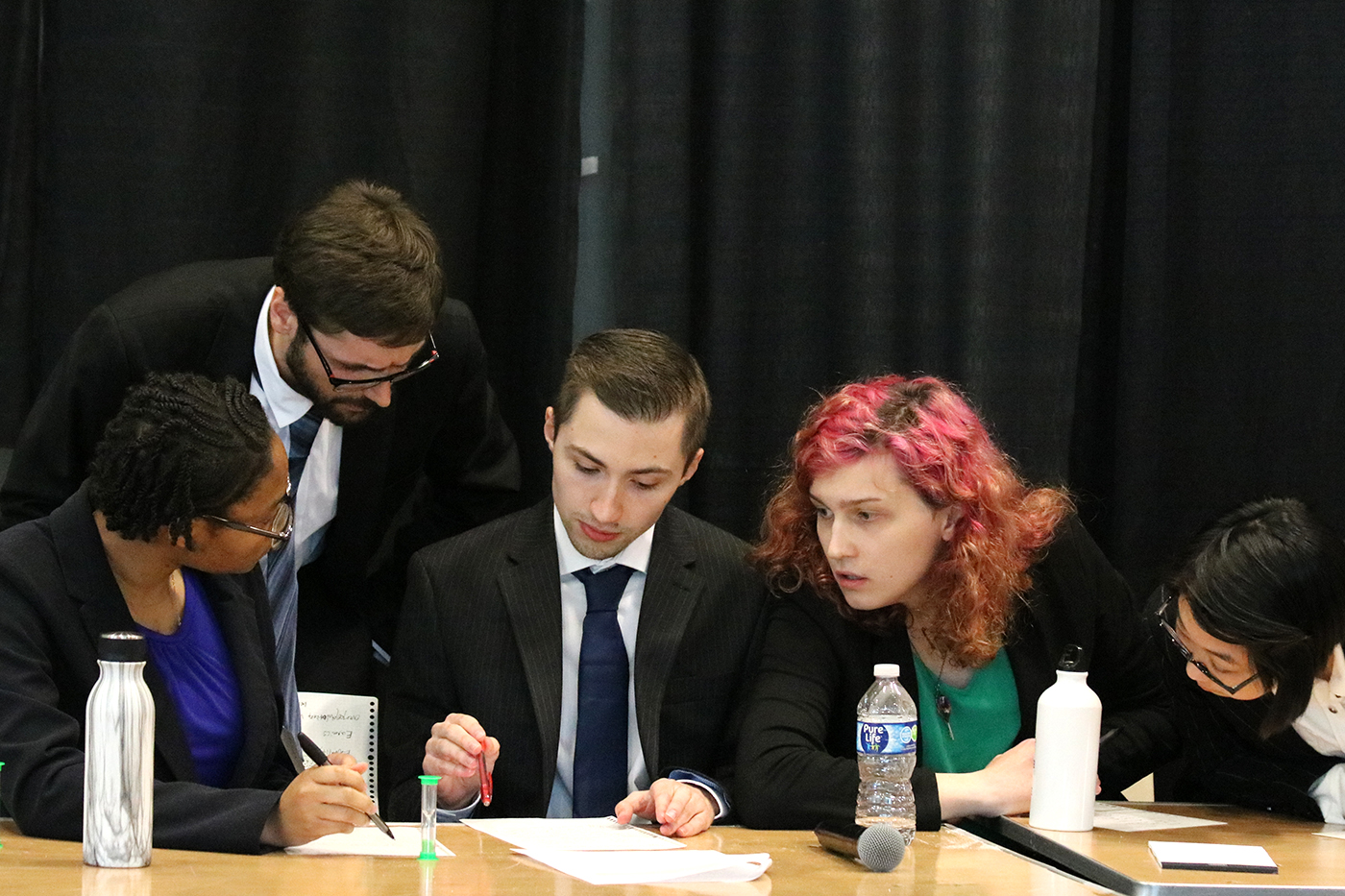 Students work on a paper together at an ethics competition.