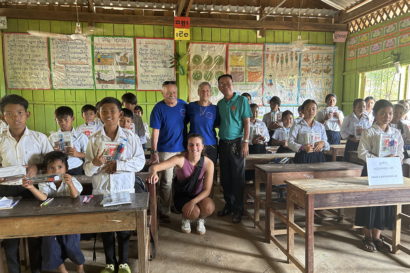 co-op student poses with Cambodian kids in a classroom