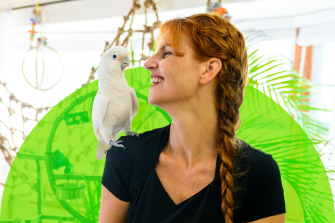 Jennifer Cunha looks at her cockatoo, which is sitting on her shoulder.