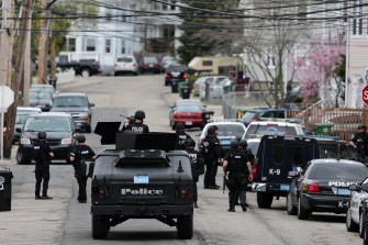 Law enforcement officers and vehicles line the streets during the manhunt for the Boston Marathon bomber.