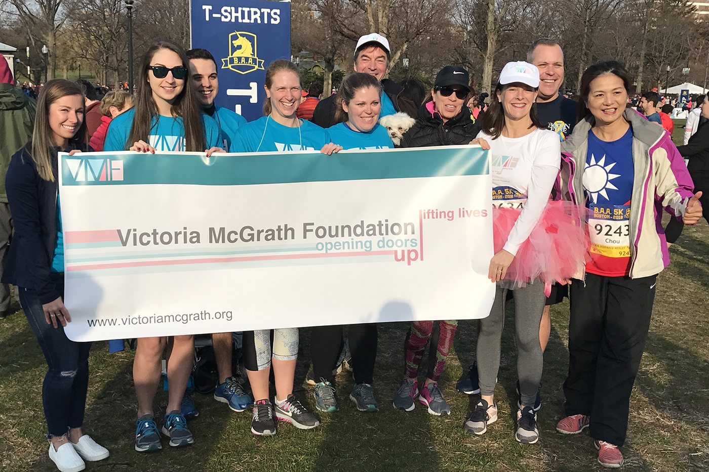 group of people holding Victoria McGrath Foundation banner