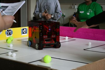 Students surround a robot.