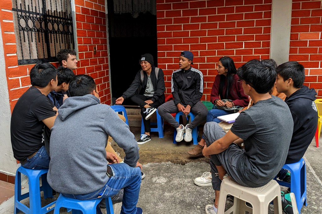 group of Ecuadorians sitting in a circle on stools