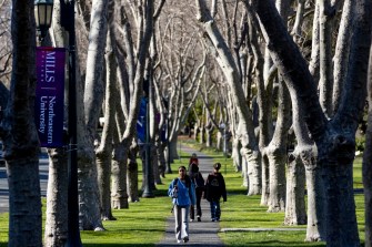 students walking on a path lined with trees at Mills College at Northeastern