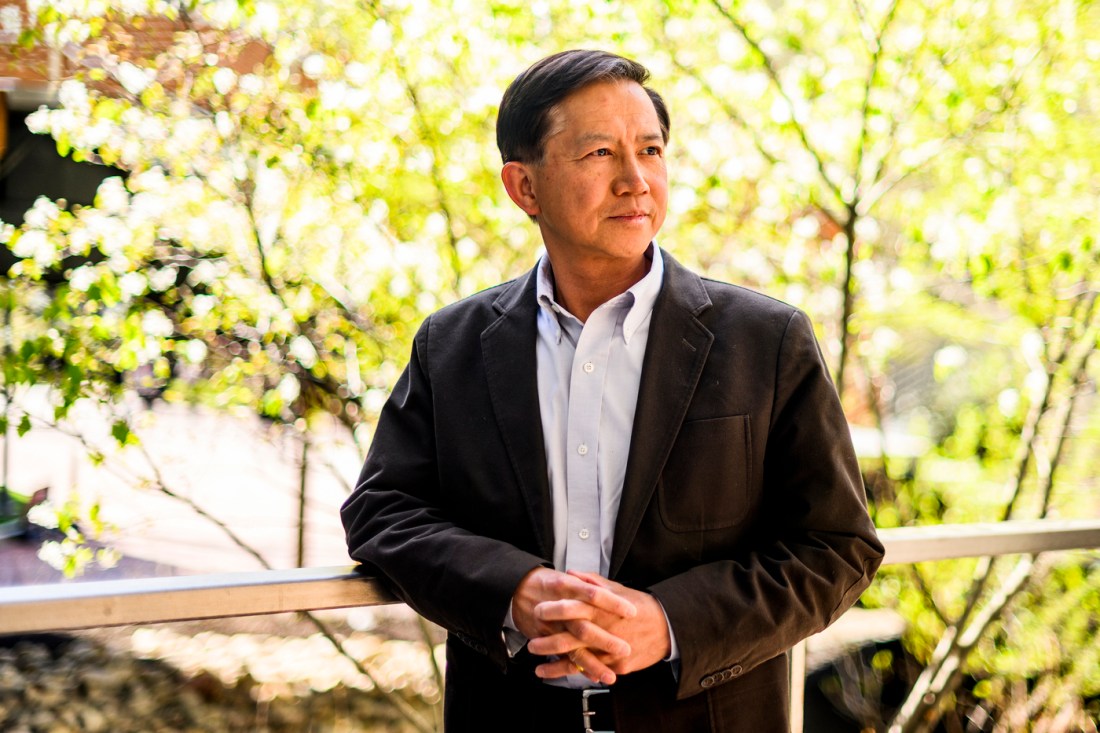 Portrait of Jim Chen standind on a balcony outside. 