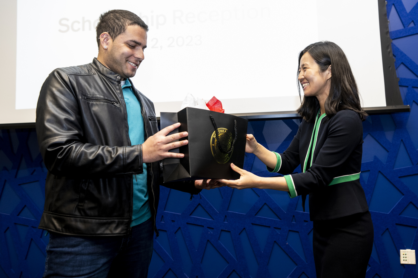 Michelle Wu presenting a gift bag to a city of Boston employee