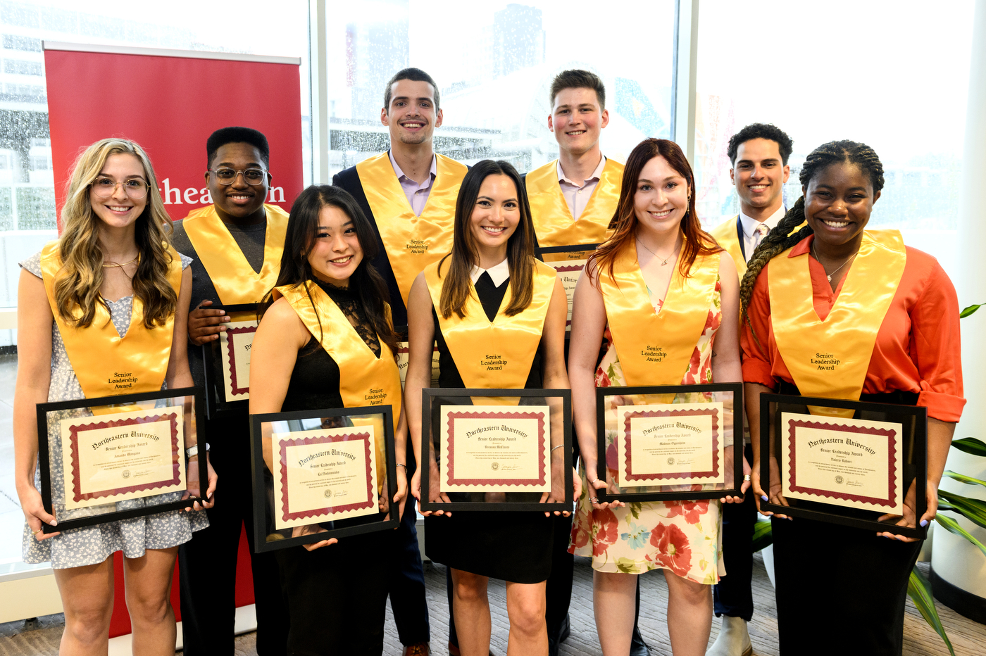 group of 9 students with gold sashes holding certificates