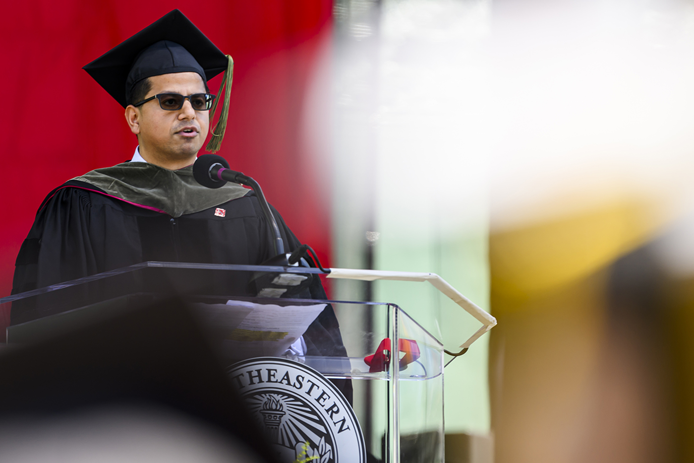 Paresh Kumar speaking at graduate commencement ceremony at Fenway Park