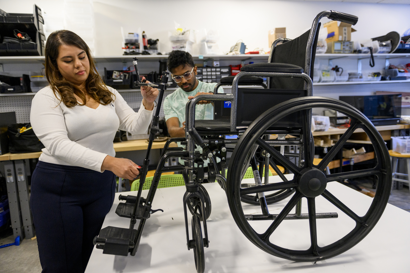 Priyanka Jalan attaching camera mount to wheelchair