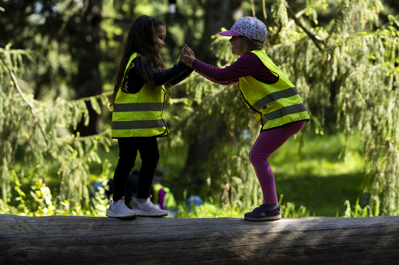 two children in neon vests playing with each other