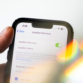person holding iPhone with location services tracking toggle on in settings