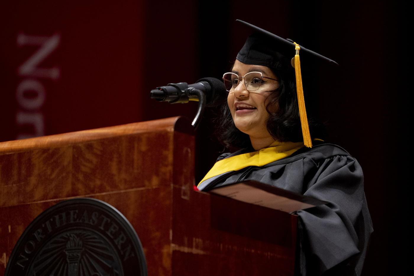 graduate speaking into microphone at commencement