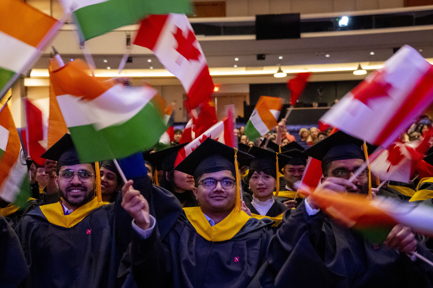 students waving flags at Vancouver convocation