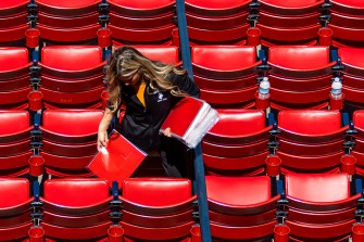 Volunteer placing red cards on the seats at Fenway Park