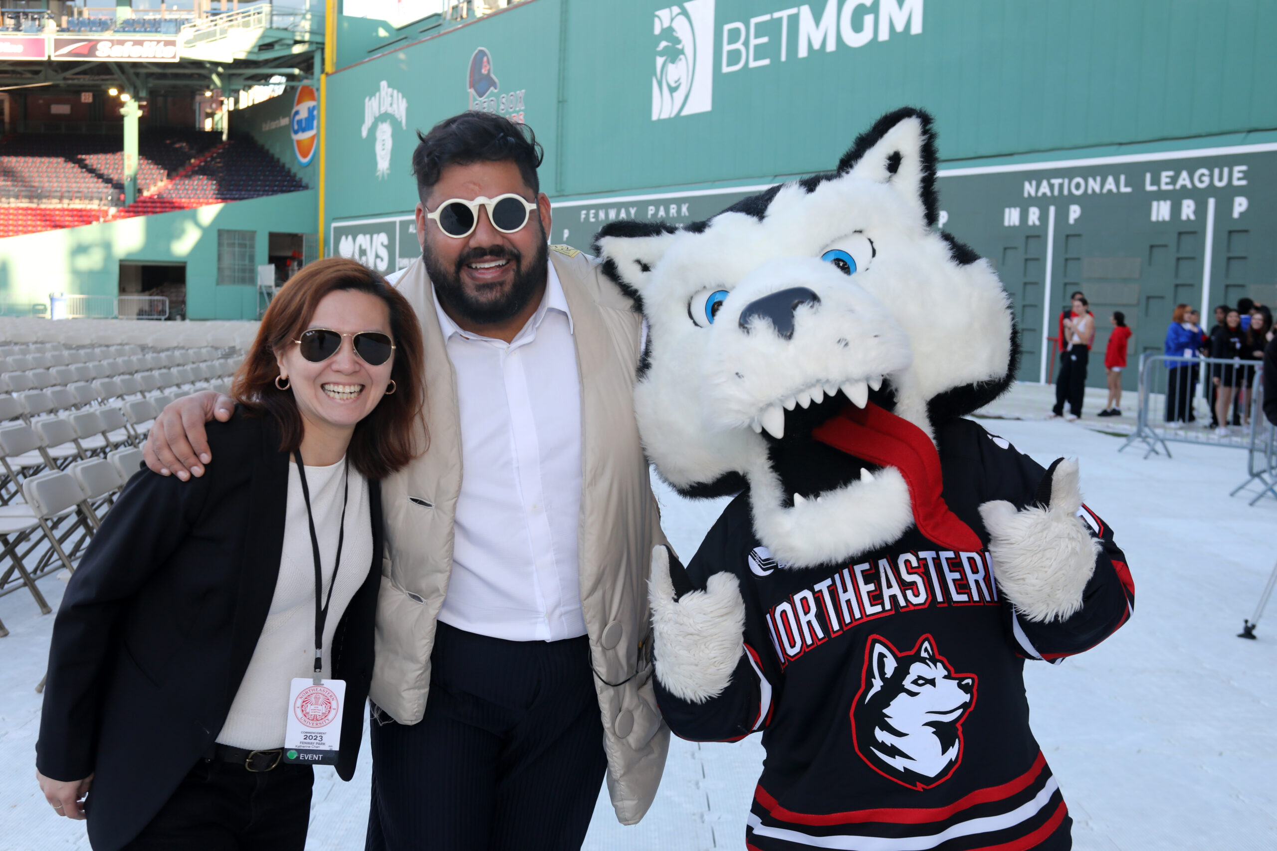 Shams Ahmed posing with Northeastern mascot Paws in Fenway Park at commencement