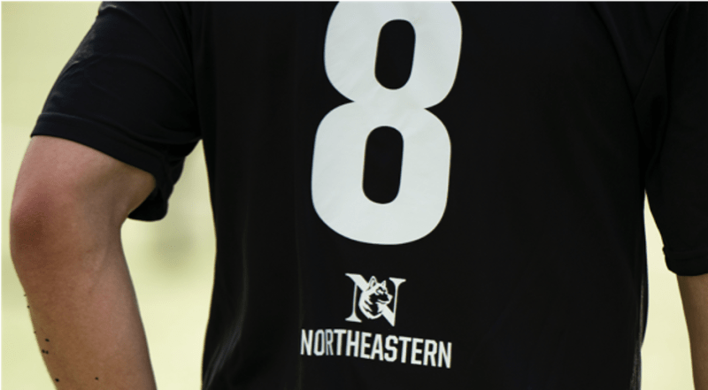 Someone wearing a black t-shirt with a large number 8 and Northeastern on the back.