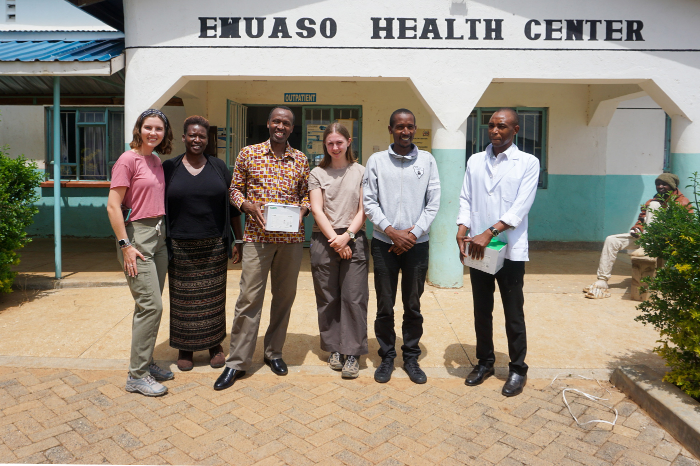 Six people stand in front of the Research on Multi-Disease and Educational Services (TERMES) Center in East Africa.