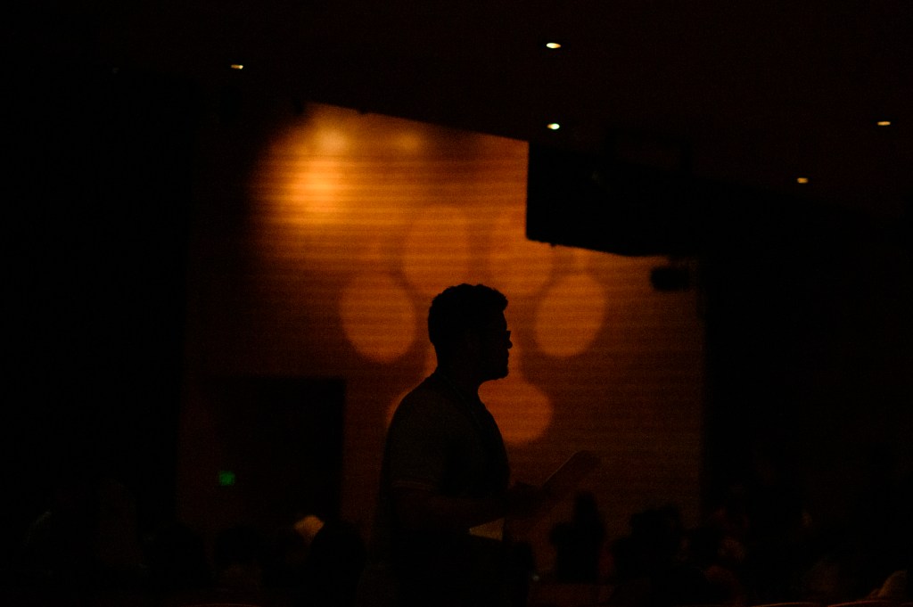 A person stands in front of a husky paw that has been projected onto a backdrop.