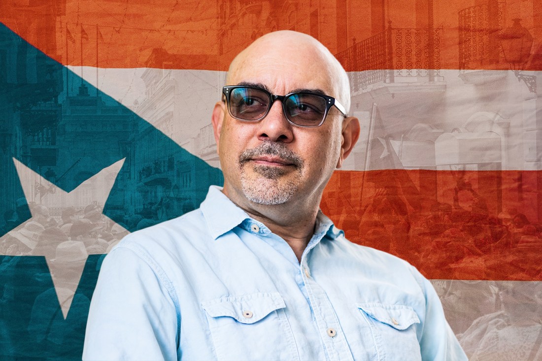 Head shot of Amílcar Antonio Barreto in front of the flag of Puerto Rico