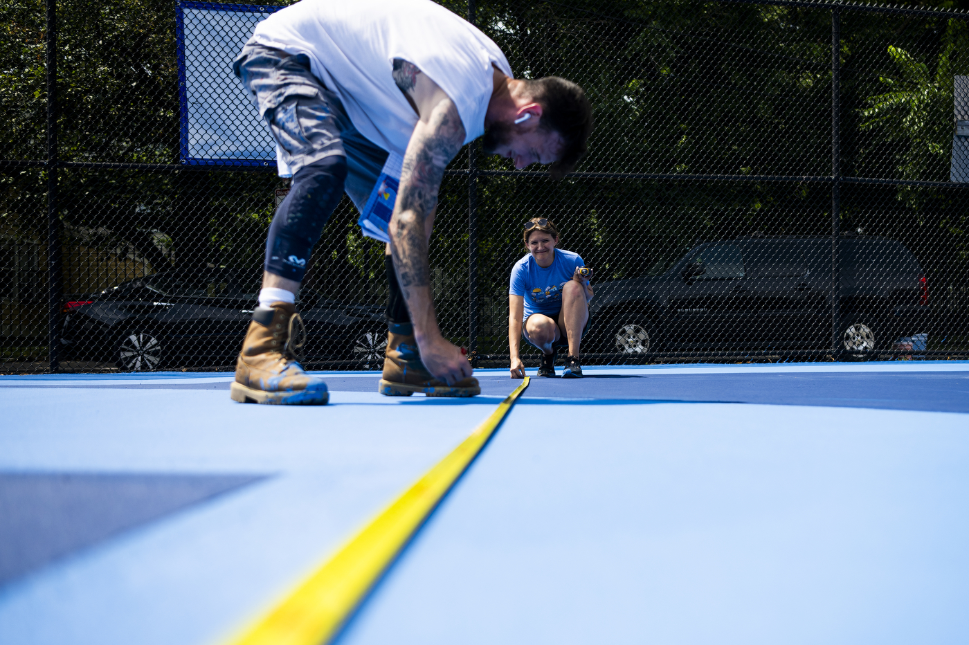people painting a basketball court