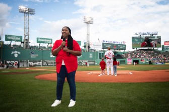 Brittany Wells singing the national anthem on the field at Fenway Park