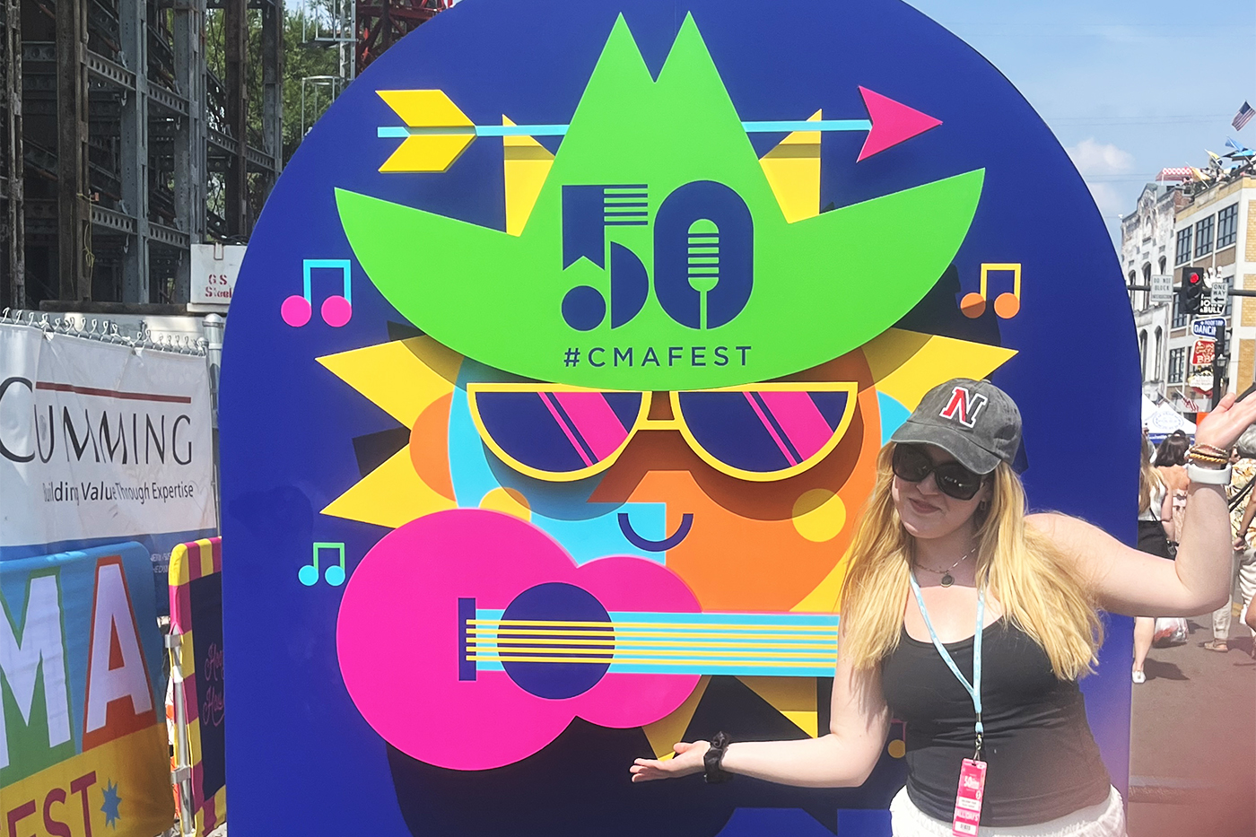 Olivia Guihan posing in front of a CMA sign at the 50th CMA Fest