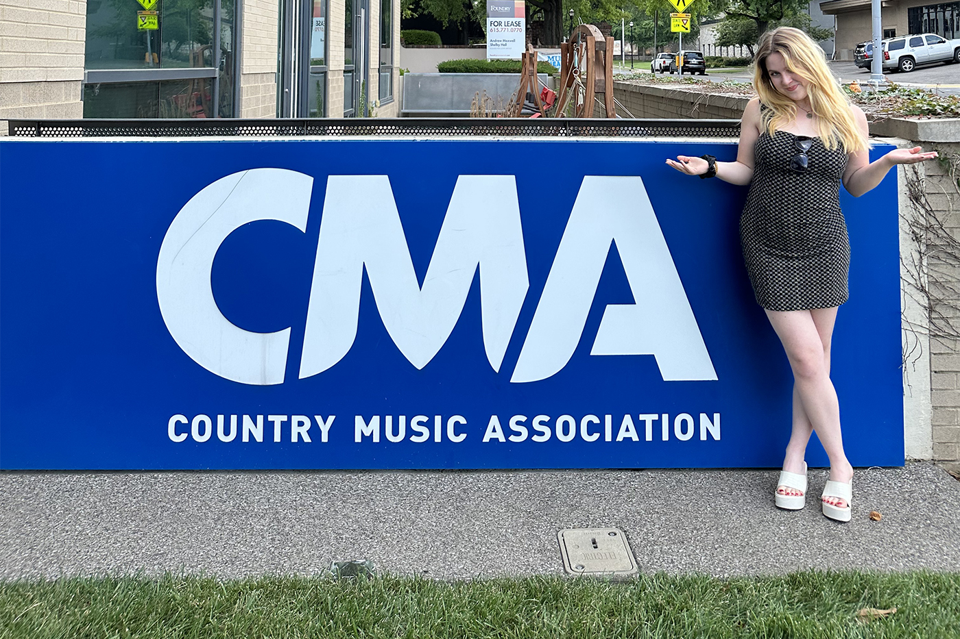 Olivia Guihan posing in front of a CMA sign