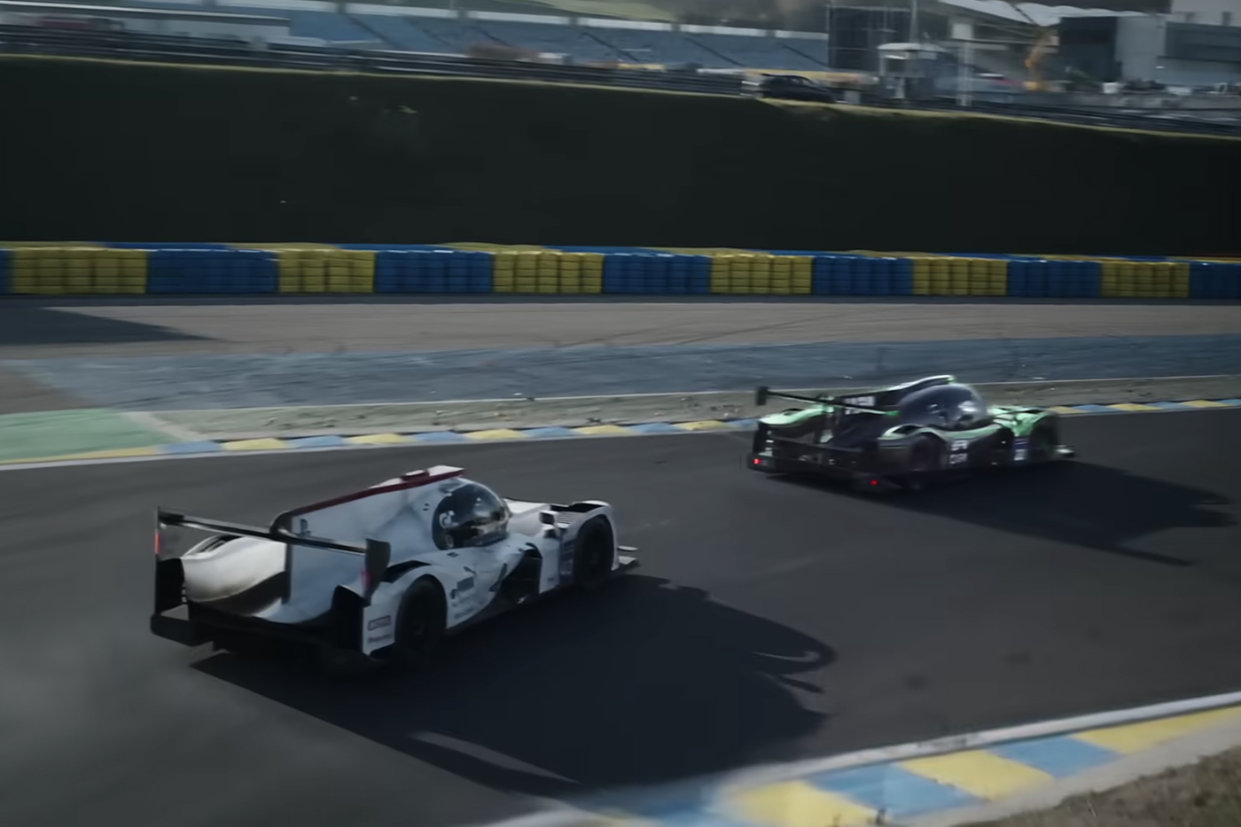 Two racecars speeding along a track