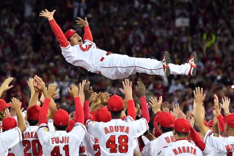 Hiroshima Toyo Carp members tossing their manager into the air