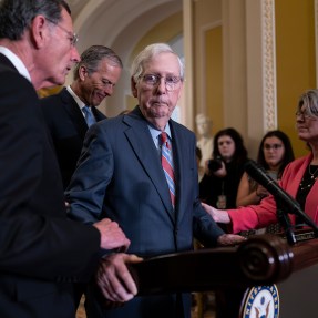 Mitch McConnell being helped by various senators when he froze at a news conference
