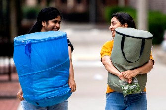 students holding bags as they move in