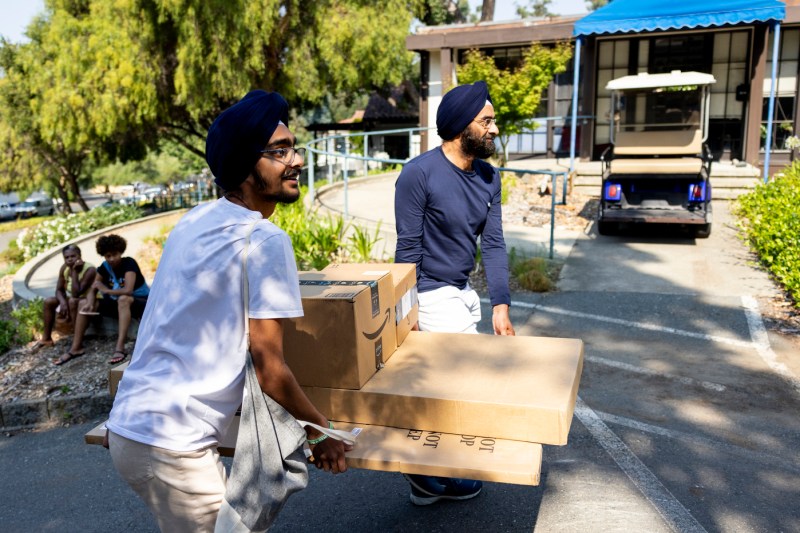 Mehr Anand and KJ Anand carrying boxes