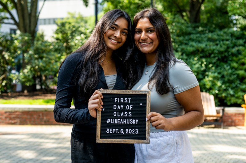 two students posing with a first day of class letterboard