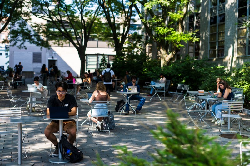 students sitting at tables outside on Northeastern's Boston campus