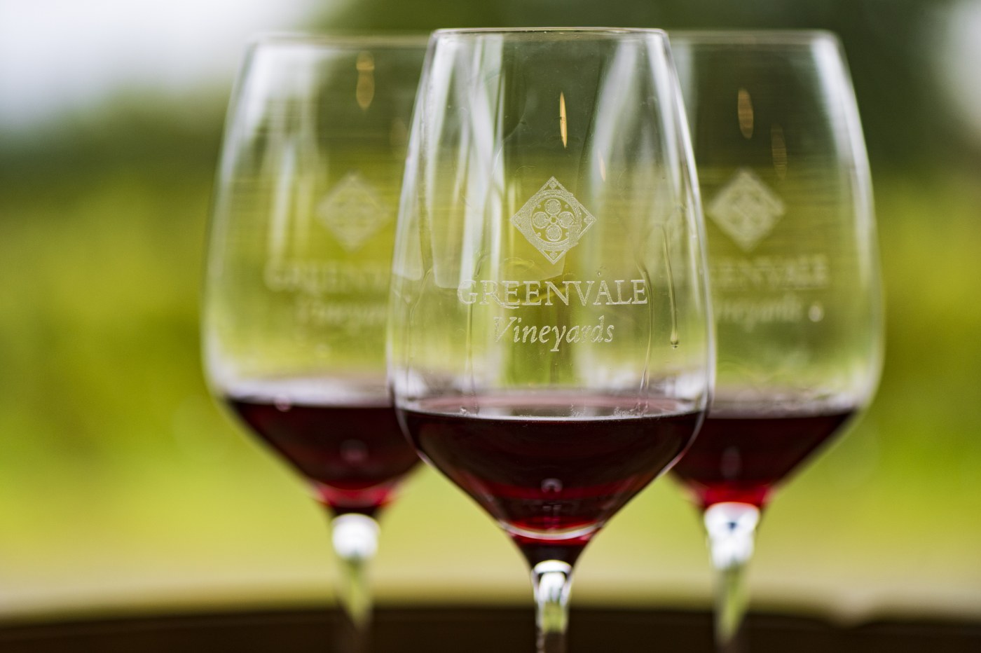 Three wine glasses embossed with Greenvale Vineyards logo. 