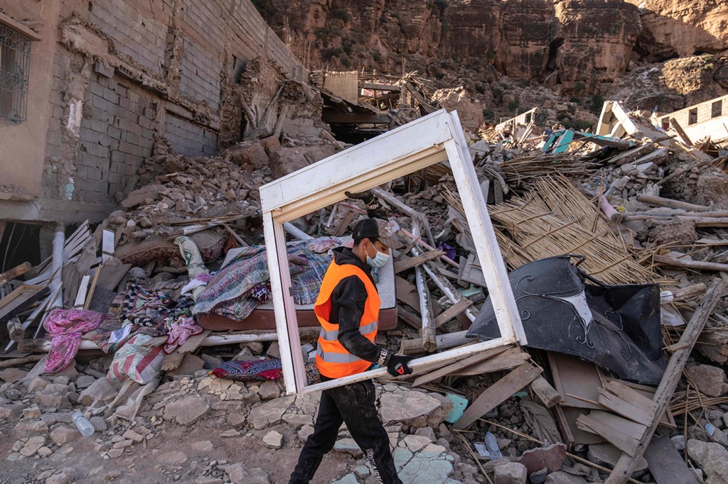 Volunteer carrying furniture from Morocco earthquake rubble.