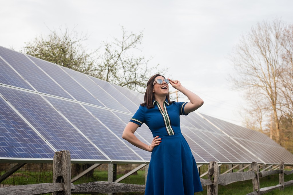 Sophie Shrand standing in front of solar panels.