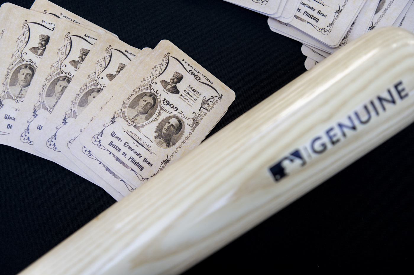 Baseball bat and historic souvenir cards that read "World's Championship Games Boston vs Pittsburg" on them